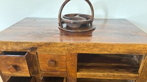 Une commode en bois avec un plateau en métal sur le dessus.