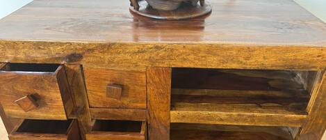 A wooden chest of drawers with a metal tray on top.