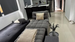 Een moderne woonkamer met een zithoek, een salontafel en een bijzettafeltje.