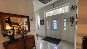 A hallway with a wooden dresser, a mirror, and a vase of flowers. - Cozy, quiet guest room with bathroom in a dream villa on the edge of the forest (Michendorf)