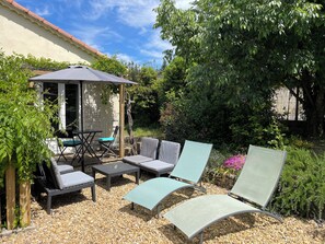 An outdoor patio with a covered seating area, a table, and chairs. - Studio in the Pine Forest with a Swimming Pool (Ales)