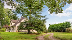 A rural house with a dirt path leading to it, surrounded by lush greenery and trees. - Dyffryn Conin is more than just a place to stay. (Clynderwen)