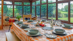 A dining area with a checkered tablecloth, set for a meal with plates, bowls, glasses, and cutlery. - Dyffryn Conin is more than just a place to stay. (Clynderwen)