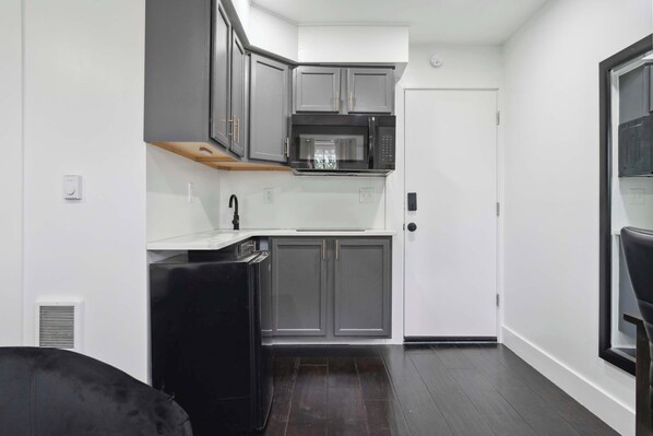 Fridge, microwave, coffee/tea maker, cookware/dishes/utensils