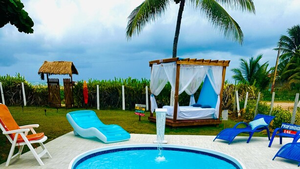 A swimming pool with a hot tub, lounge chairs, and a canopy structure. - Wonderful Beachfront House 2 - Next to the Natural Pools, Brazilian Caribbean. (São José da Coroa Grande)