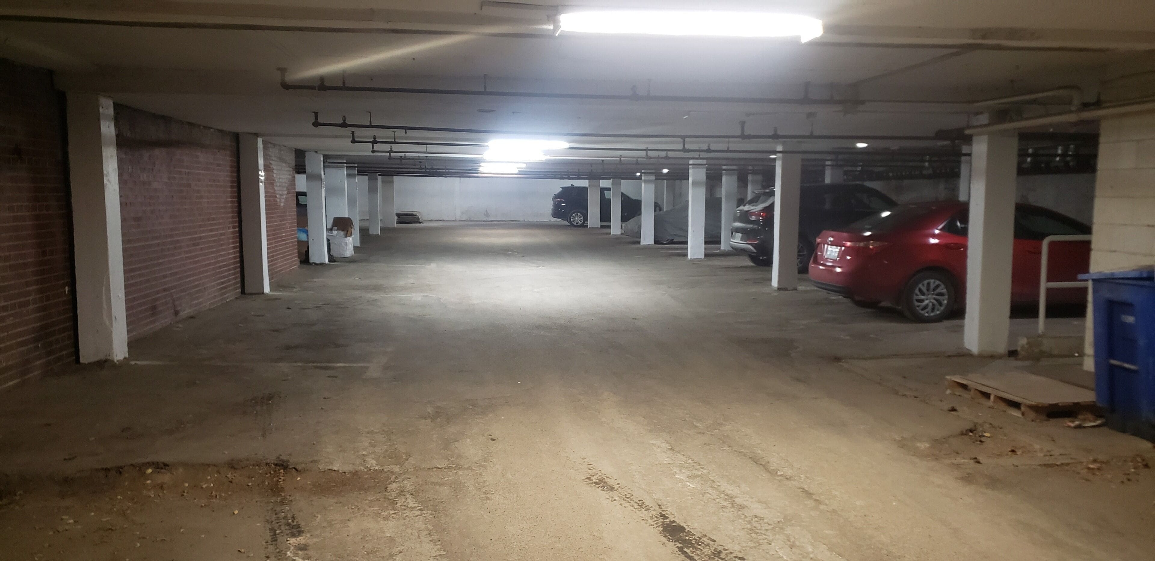 Eine mehrgeschossige Parkgarage mit Betonböden und weißen Säulen.