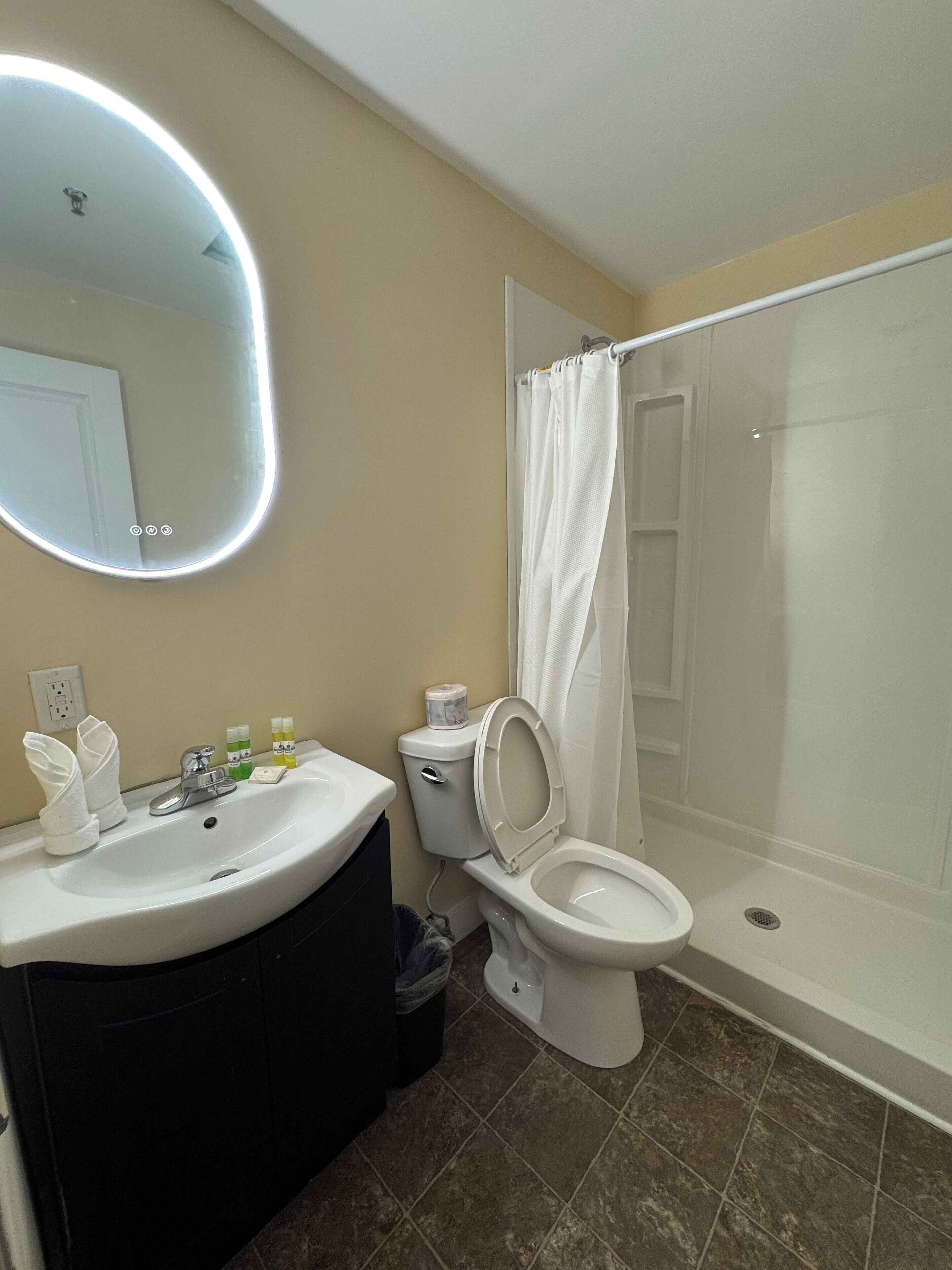 A bathroom with a sink, toilet, and shower.
