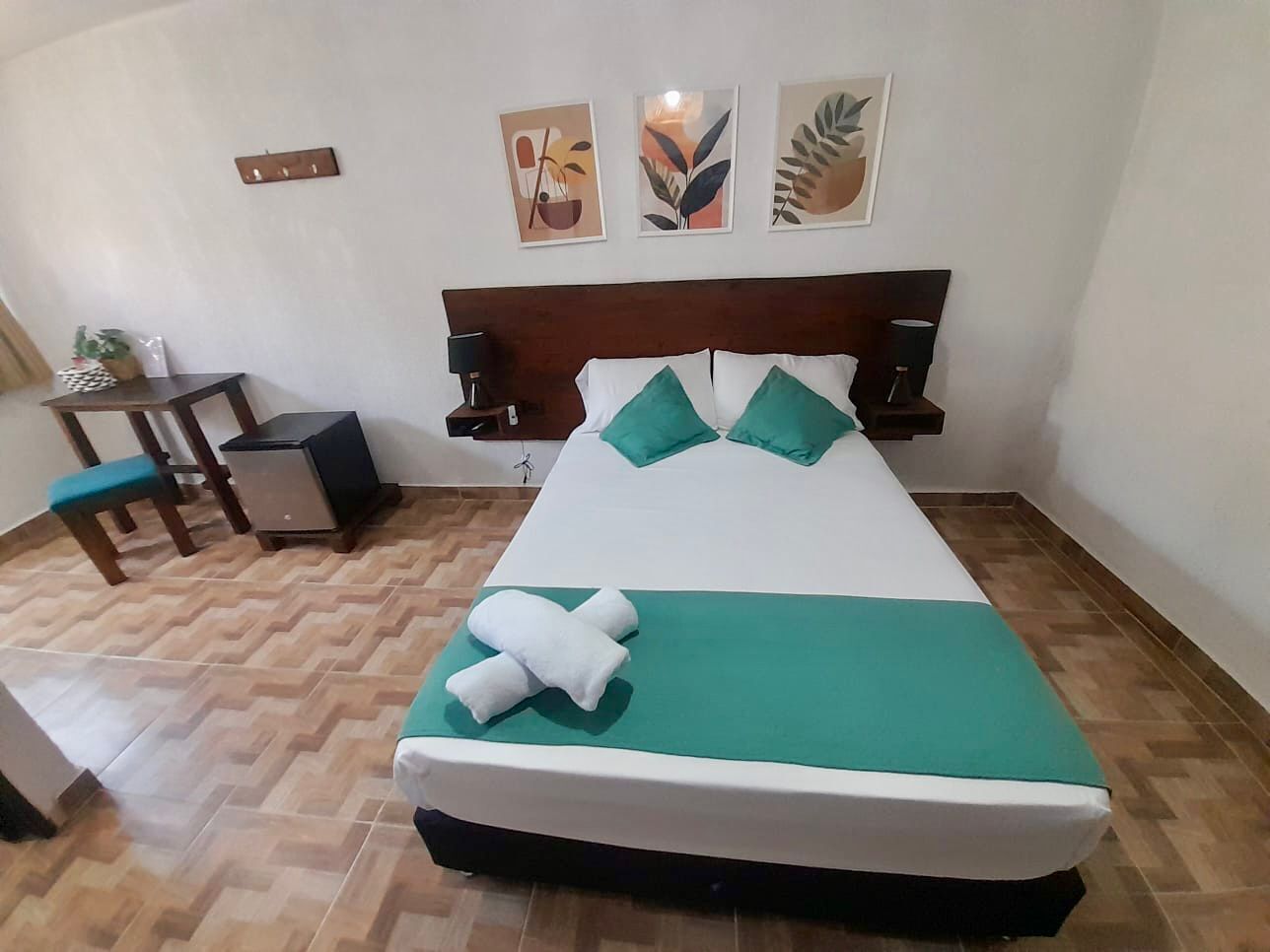 A neatly arranged hotel room with a bed, a small table, and chairs.