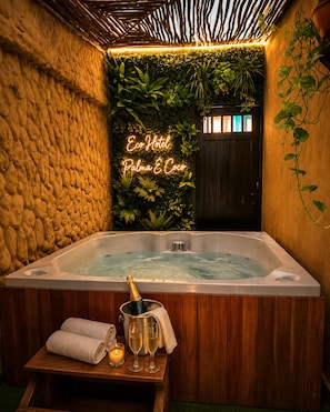 A hot tub with a neon sign, surrounded by greenery and wooden walls. - eco hotel palma É coco (San Andrés)
