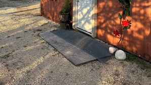 Un edificio rustico con facciata in legno, una porta bianca e una piccola finestra.
