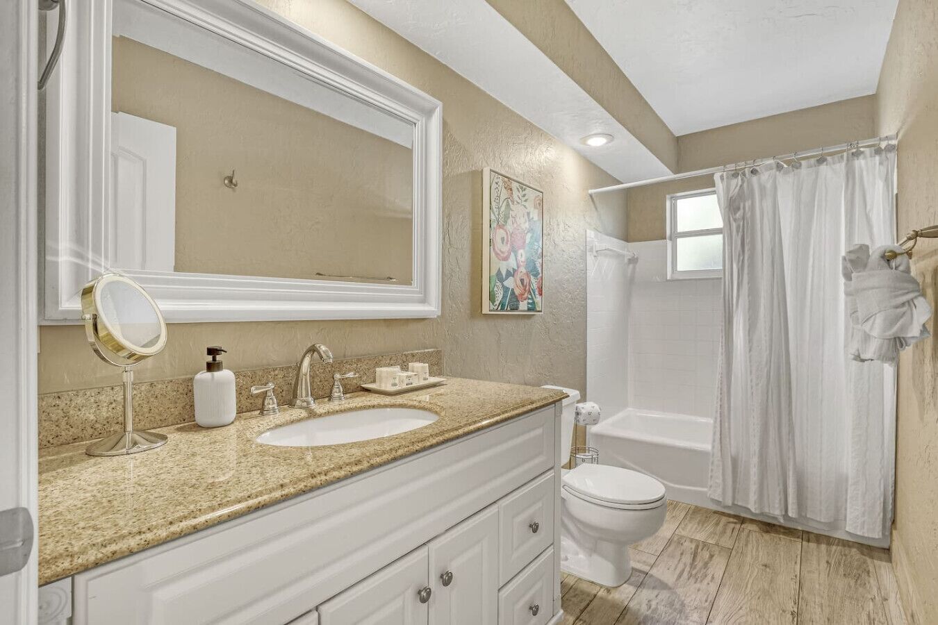 Une salle de bain avec deux lavabos, un grand miroir, des toilettes et un espace douche.