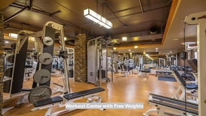 A workout center with free weights, including a bench press and various weight machines.