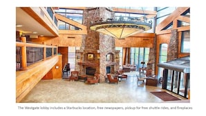 A spacious lobby with a stone fireplace, comfortable seating, and a Starbucks location.