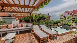 A rooftop terrace with a wooden pergola, lounge chairs, a sofa, and a hot tub. - Casa Bovedas - 5 Bedroom Paradise (Cartagena de Indias)