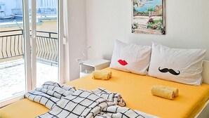 A hotel room with a bed, two pillows, a window with a view, and a small bedside table. - Lovely apartment in Jadranovo with WiFi (Jadranovo)
