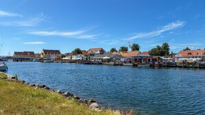 Een waterkant met gebouwen, boten en een heldere lucht.