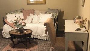 A cozy bedroom with a bed, a small table with a vase, a chair, and a desk with a mirror. - Charming 2-bedroom townhome in welcoming Auburn with AC, WiFi, 1897 Sqare feet (Auburn)