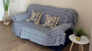 A modern living room with a sofa, decorative wall art, a small table, and a potted plant. - Herdade da Yucca (Alandroal)