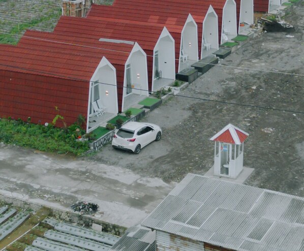 A row of white, arched structures with a red roof, possibly a hotel or resort. - Dieng Luxury Camp By Travelink (Kejajar)
