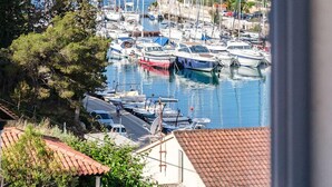 A marina with boats docked, surrounded by houses with red-tiled roofs, and a clear view of the sea. - Charming 4-BR Villa with Heated Pool and Sea Views, Close to Beach (Milna)