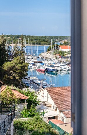 A marina with boats docked, surrounded by houses with red-tiled roofs, and a clear view of the sea. - Charming 4-BR Villa with Heated Pool and Sea Views, Close to Beach (Milna)