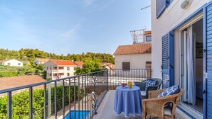 A balcony with a pool, wicker furniture, and a table with a blue tablecloth. - Charming 4-BR Villa with Heated Pool and Sea Views, Close to Beach (Milna)