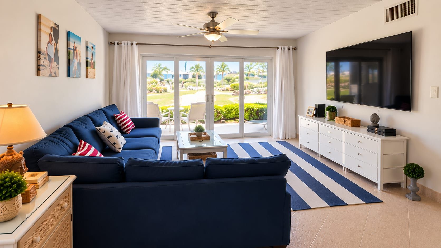 A living room with a blue sofa, a coffee table, a TV, and a view of a garden through the glass door.
