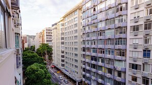 Un hotel de varios pisos con balcones, vista a la calle y cielo despejado.