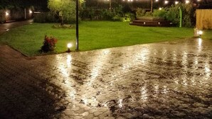 A nighttime outdoor area with string lights, a paved walkway, and a grassy lawn. - Relaxation with Jacuzzi and pool between Pompeii Amalfi coast, Sorrento and Capri (Trecase)