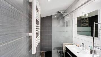 Een haardroger, handdoeken, zeep, toiletpapier