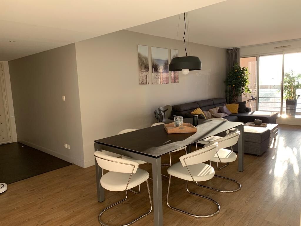 Un salon moderne comprenant un coin repas, un canapé et une grande fenêtre offrant une belle vue.