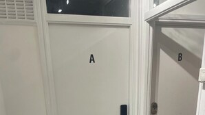 A hallway with two doors labeled A and B, each with a doorbell and a keyhole.
