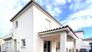 Une maison moderne dotée d’une piscine, d’une terrasse en bois et d’un patio couvert.
