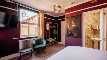 Un dormitorio moderno con una cama grande, un sillón verde, una lámpara colgante y vistas al exterior.