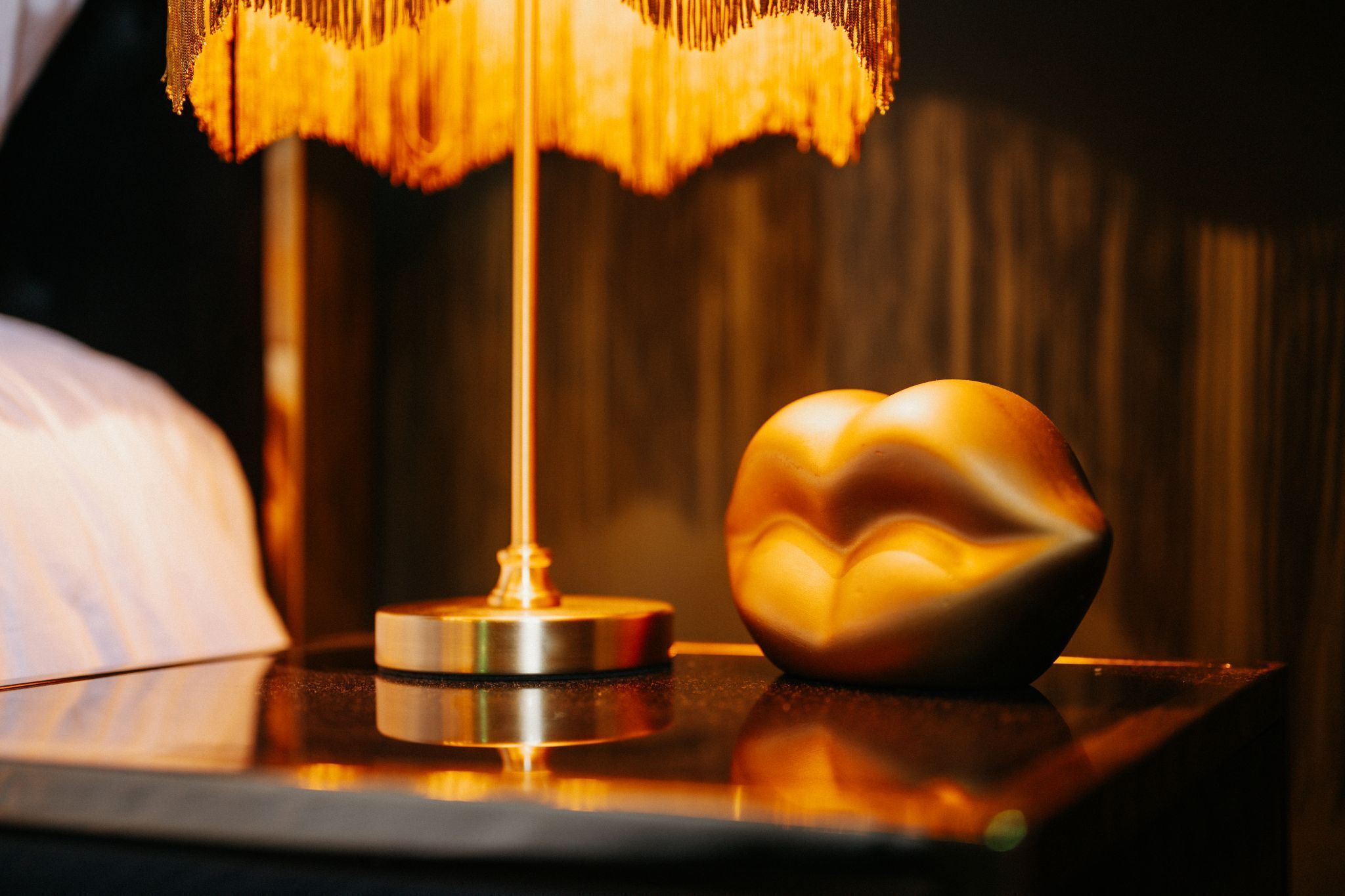 Una mesa con una lámpara y un objeto con forma de corazón.