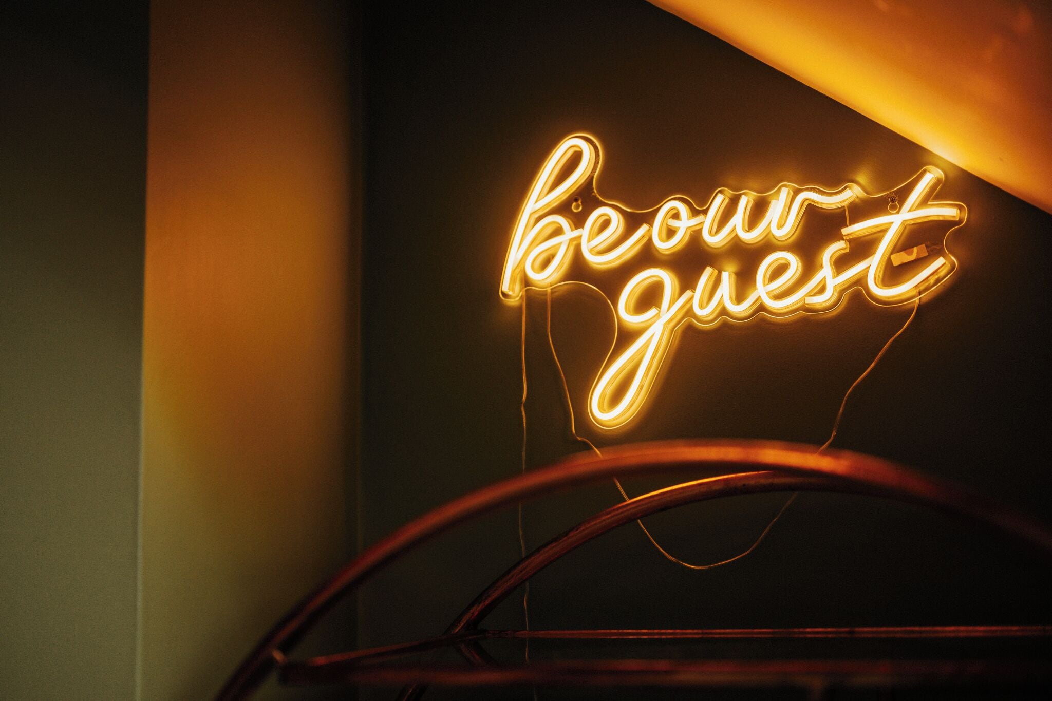 A neon sign with the text "beour guest" in a stylized font.