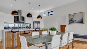 A modern kitchen with a central island, stainless steel appliances, and pendant lighting.