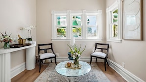 A room with a marble coffee table, two chairs, a vase with flowers, a champagne bottle, and a decorative tray. - Hennessey Estate  (Napa)