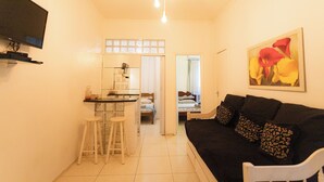 A compact living space with a kitchenette, a dining area, and a seating area with a couch and chairs. - 360 Copa Beach NSC By SUHCasa (Rio de Janeiro)