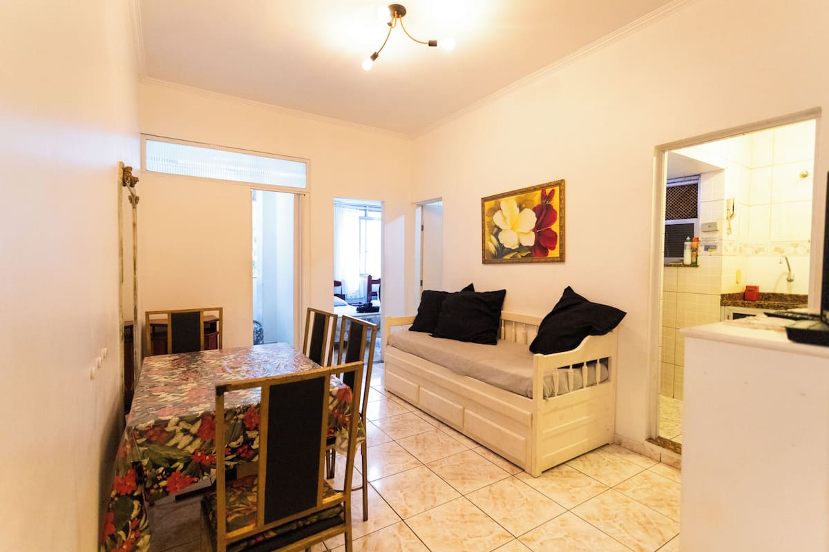 A compact living space with a dining area, sofa, and kitchen.