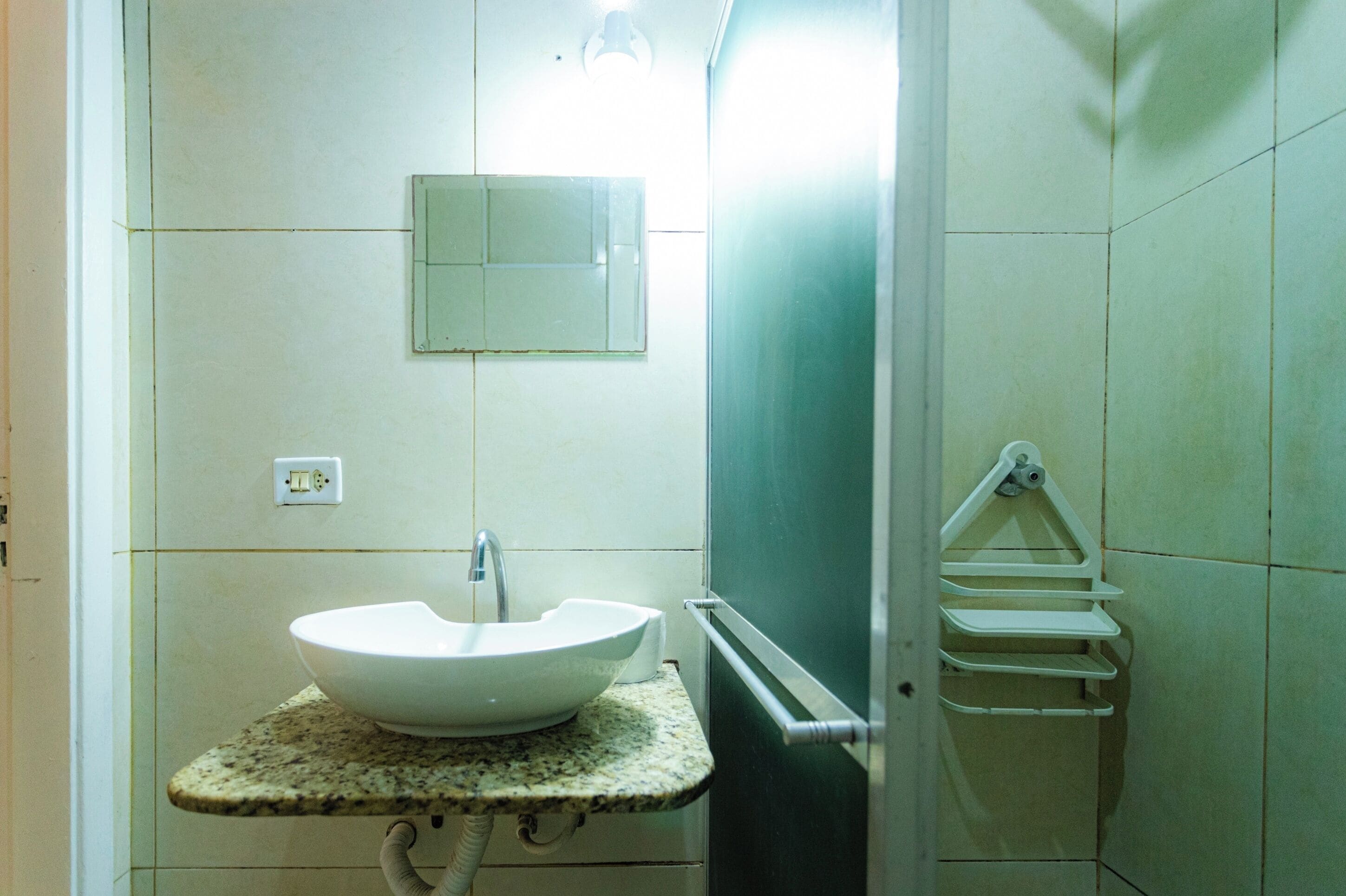 A bathroom with a white sink, a mirror, and a towel rack.
