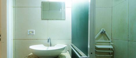 A bathroom with a white sink, a mirror, and a towel rack.