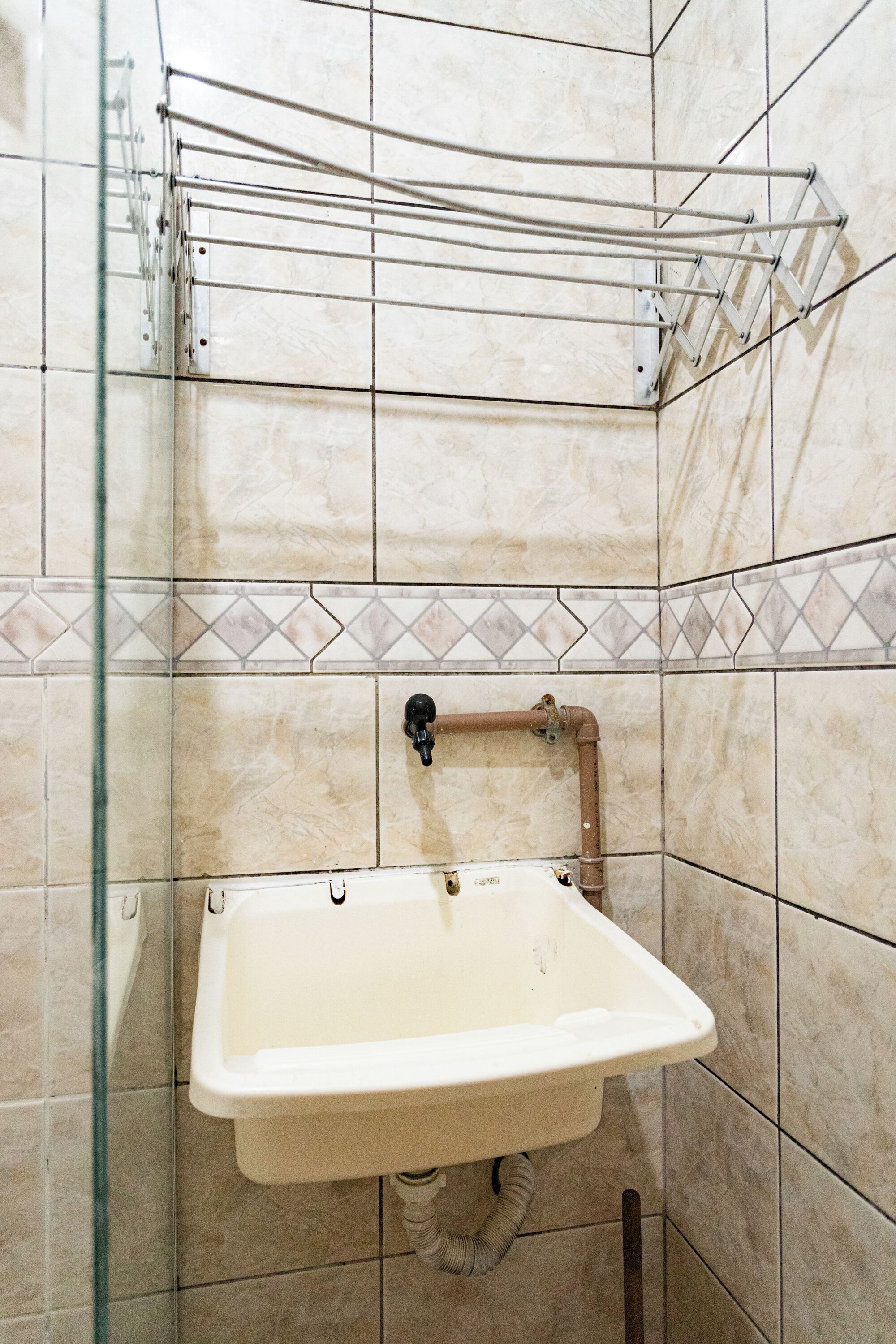 A bathroom with a sink, a shower, and a towel rack.