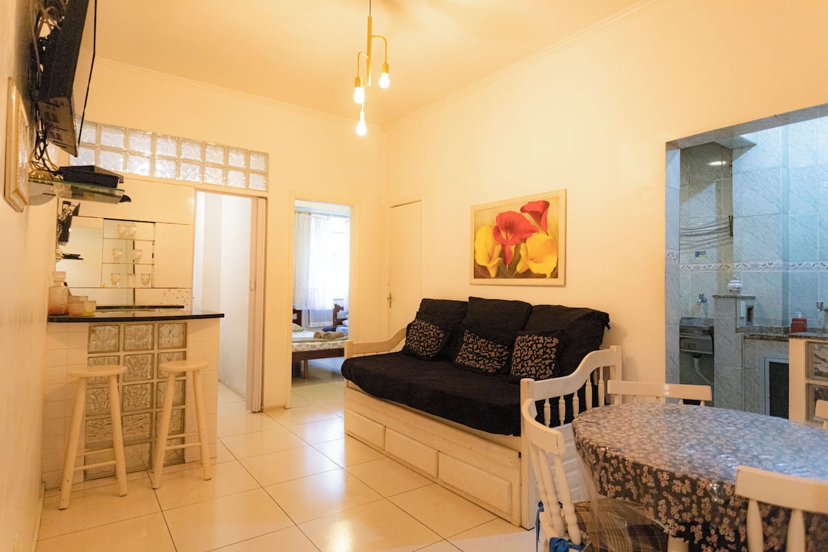 A compact living space with a kitchenette, a sofa, and a dining table.