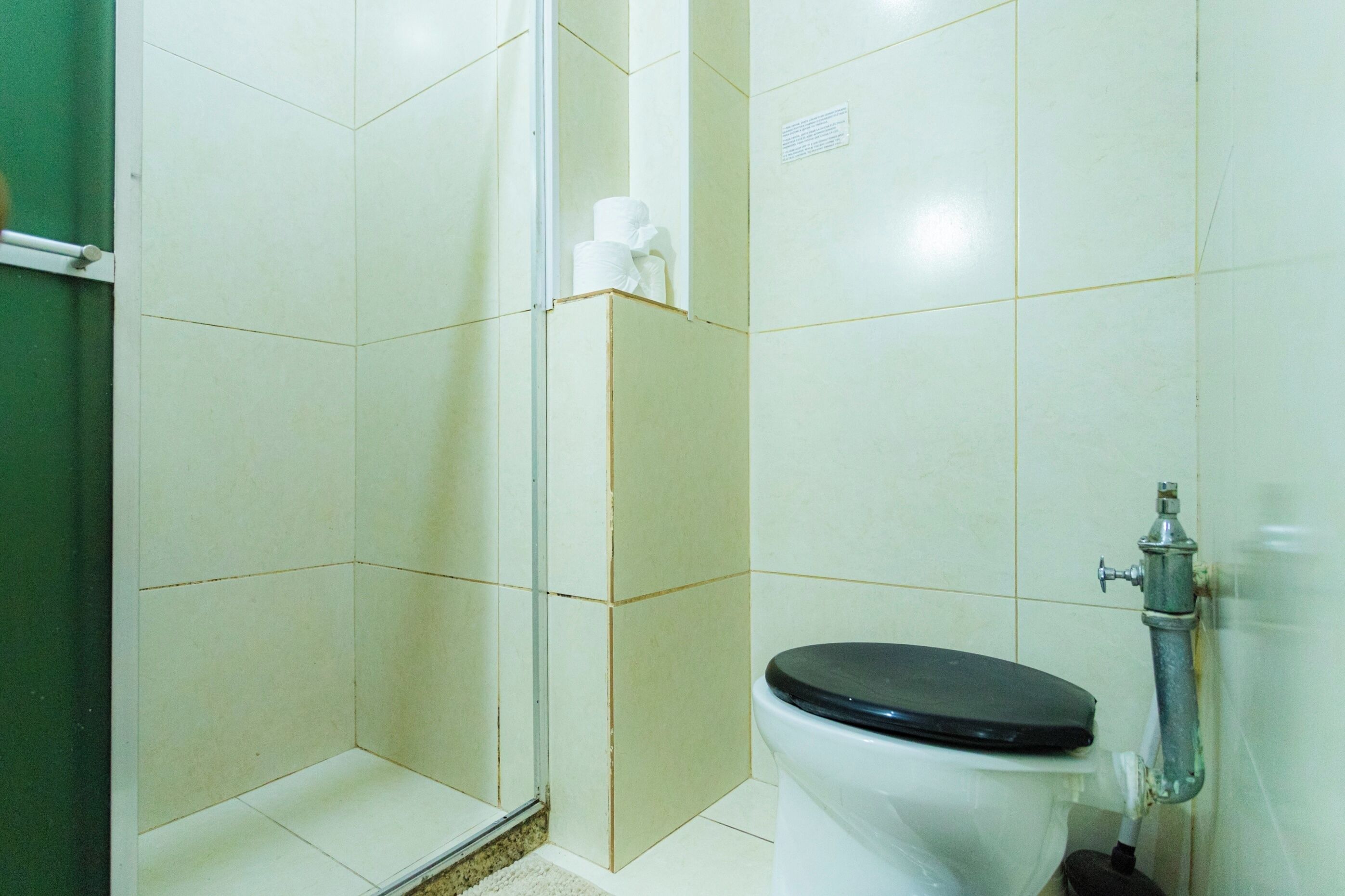 Une salle de bain équipée de toilettes, d’une douche et d’un sèche-mains.