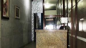 A hallway with a reception desk, marble walls, and a patterned rug. - 360 Copa Beach NSC By SUHCasa (Rio de Janeiro)