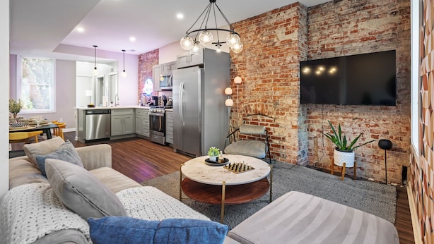A modern living room with a sofa, coffee table, and a brick wall.