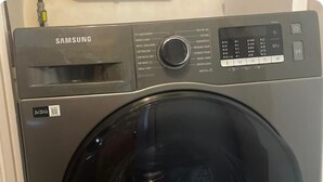 Una lavadora Samsung de carga frontal con panel de control y pantalla digital.