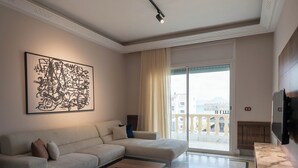 Una sala de estar moderna con un sofá modular, una mesa de centro y un cuadro abstracto grande.