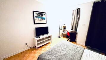 2 habitaciones, escritorio y tabla de planchar con plancha